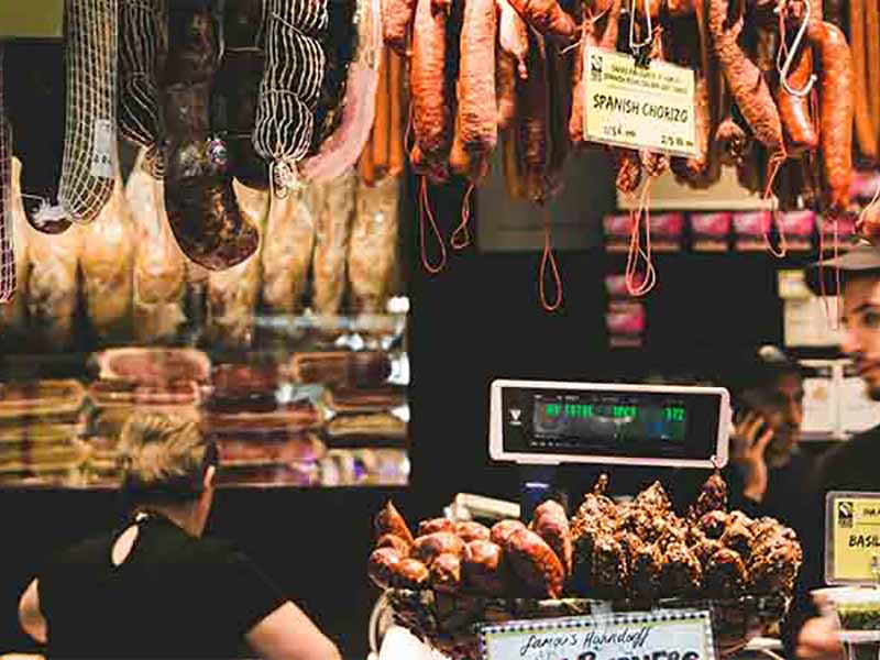 Cured meats hanging above a butcher's counter